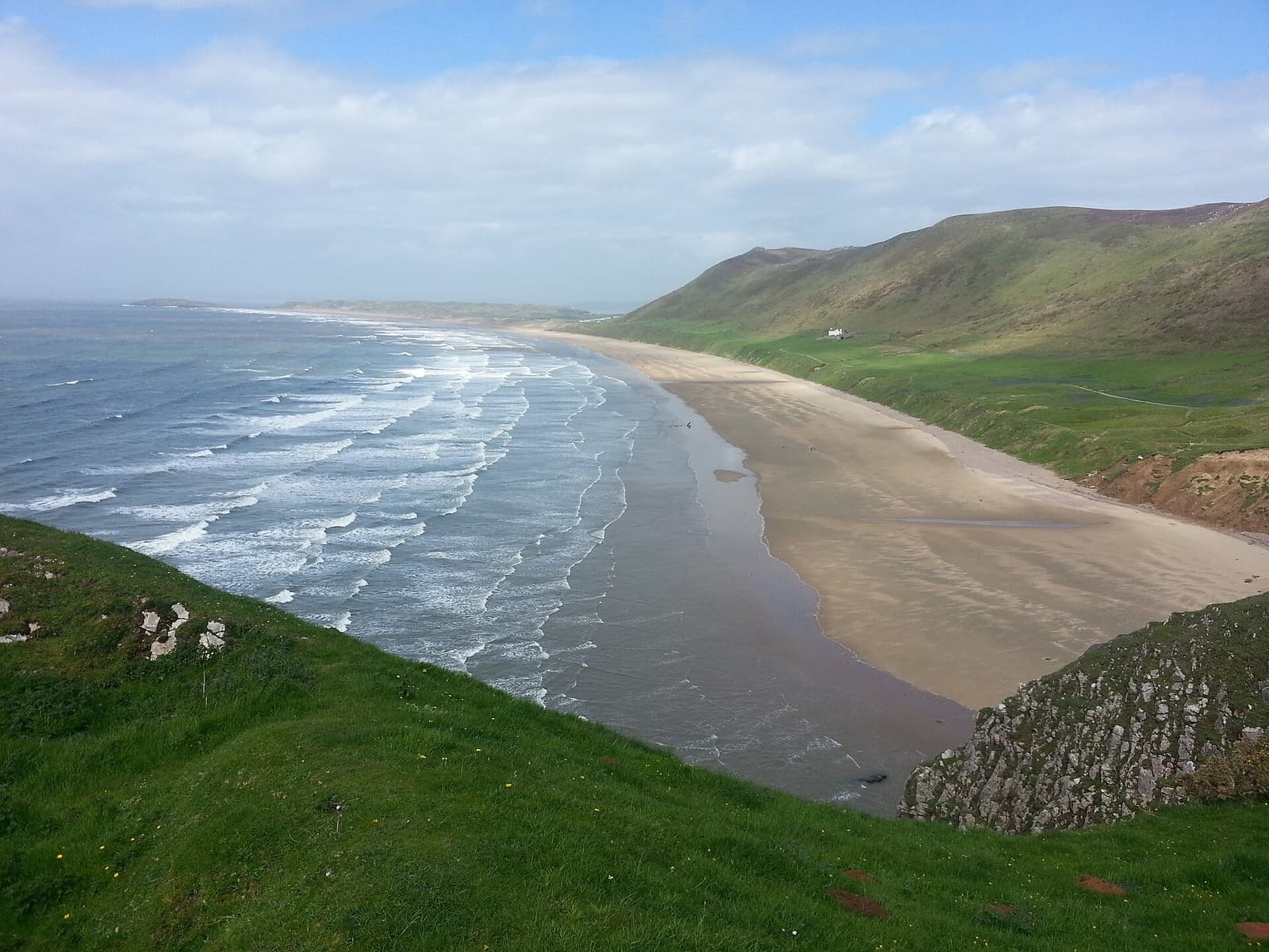 Die Rhossili Bay schwingt sich unterhalb des Rhossili Down auf der Gower-Halbinsel in die Ferne