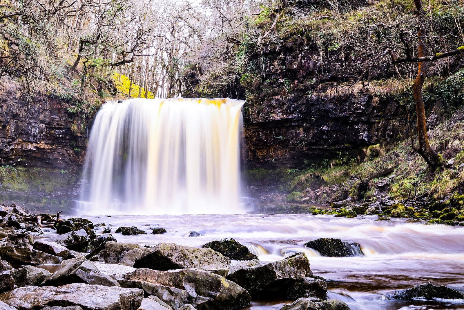 Der Wasserfall Sgwd yr Eira fällt wie ein Vorhang über seine Felsstufe