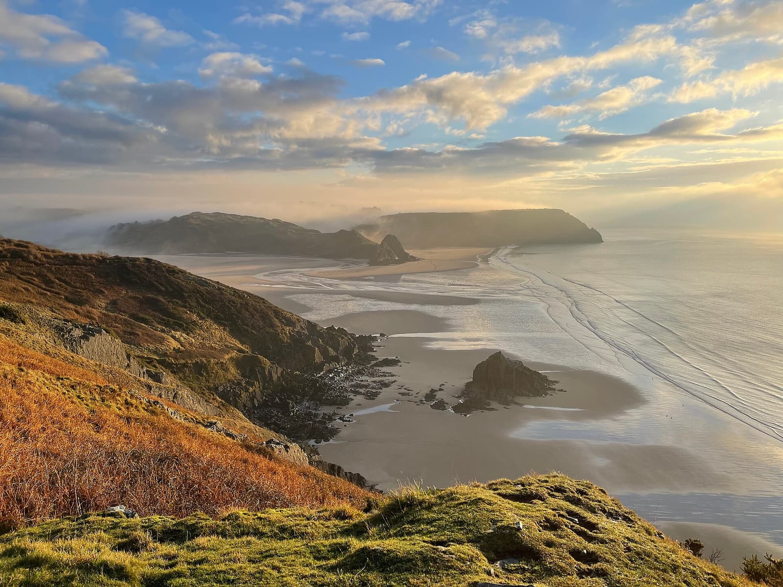 Kalksteinklippen und goldener Sand an der Südküste von Gower